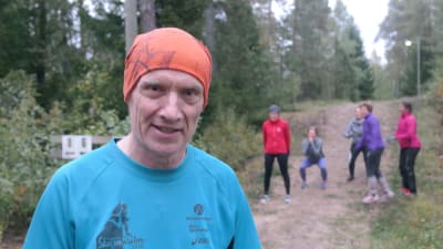 Evert Nilsson sysslar med CrossNature i en skog i Pargas, i bakgrunden andra deltagare
