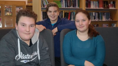 Ungdomarna Joacim Oksanen, Viggo Henelius och Olivia Numminen i biblioteket i Kimito