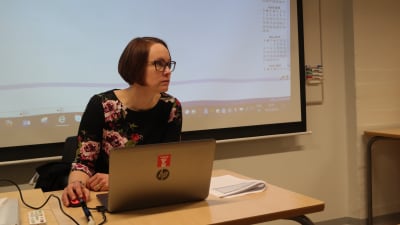 Turismlärare Erika Silvetoinen sitter i katedern med en dator