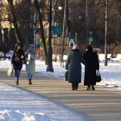 Kvinnor som går på en gata i ett snöigt Ryssland.