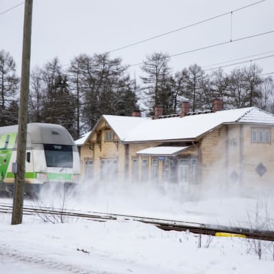 Juna ajaa Piikkiön vanhan rautatieaseman ohi talvisäässä. 