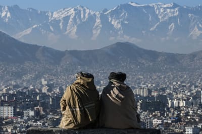 Talibaner tittar på staden Kabul. Berg i bakgrunden.