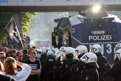 Demonstrant står öga mot öga med kravallpolisen i Hamburg.