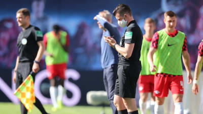Fjärdedomaren Alexander Sather använder sig av ett andningsskydd under matchen mellan Leipzig och Freiburg.