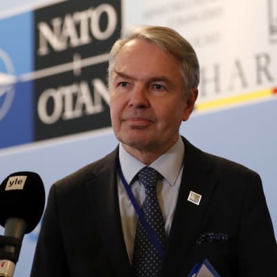 Pekka Haavisto framför Nato-symbol och YLE-mikrofon