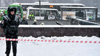 Polisen övervakar gångtunneln medan räddningspersonal arbetar intill olycksbussen. Moskva 25.12.2017.