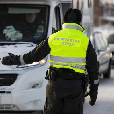 En person vid gränsbevakningen vinkar in en bil vid Torneå-gränsen.