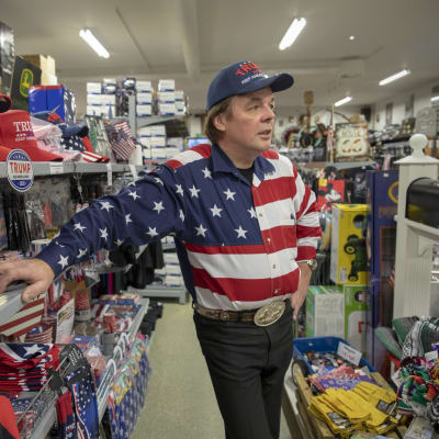 Jari Mäki Trump-rekvisiittahyllyn edessä myymälässään