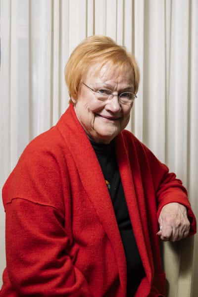 President Tarja Halonen i en röd jacka i närbild. 