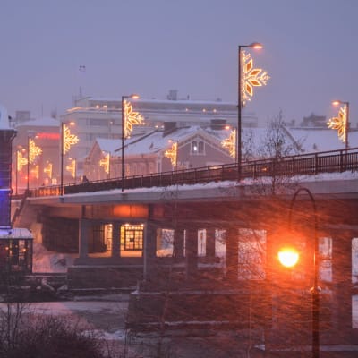 Upplyst bro i vinterstorm. 