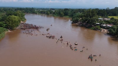 Migranter vadar över gränsfloden Suchiate mellan Guatemala och Mexiko på måndagen 29.10.