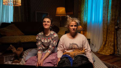 Safin universumissa näyttelevät Safi (Johanna Öhman) ja Riikka (Emilia Jansson) istuvat patjojen päällä lattialla.