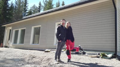 Caroline Eriksson och Fredrik Kuni framför husbygget