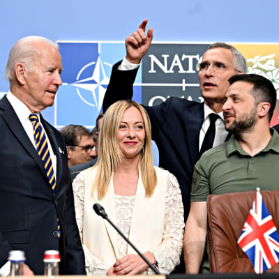 Rishi Sunak, Joe Biden, Giorgia Meloni ja Volodymyr Zelenskyi eturivissä, Naton pääsihteeri Jens Stoltenberg viittoloi kädellään heidän takaa.