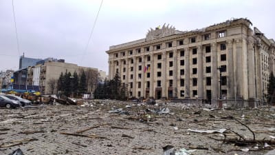 En skadad förvaltningsbyggnad i Charkiv. Marken är full av skräp och bråte efter bombnedslag.