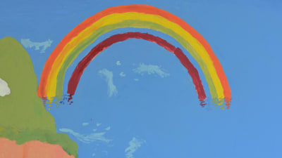 En väggmålning som föreställer en regnbåge. Ljusblå bakgrund.