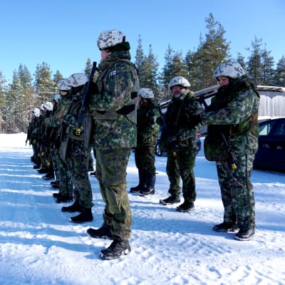Personer i militäruniform står i formation.