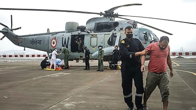 Indiska flottan räddade personer från pråmen som sjönk med helikopter.