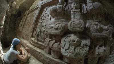 Arkitekt studerar fris från mayakulturen i Petén.