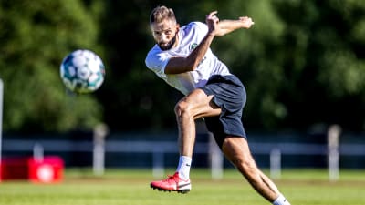 En fotbollsspelare sparkar en boll. 