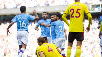 Manchester City firar mål bakom Watfordspelare.