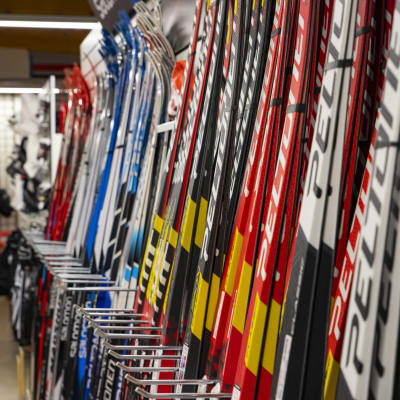 Nya färggranna skidor på rad i en hylla i en sportaffär.
