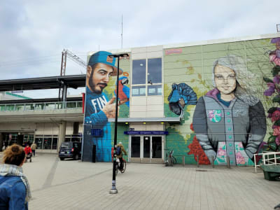 Muraler som föreställer människor, vid en tågstation.