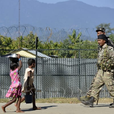 Barn och militär promenerar i den nordöstra delstaten Assam.