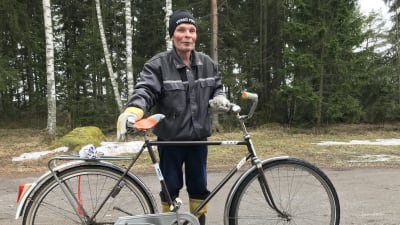 Håkan Weckström vid sin cykel, skog i bakgrunden.