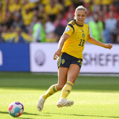 Svensk spelare i gul spelblus passar bollen.