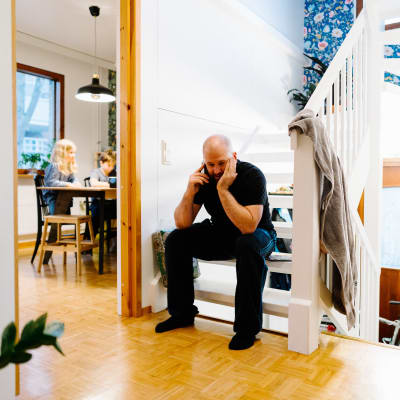 Jarkko Mandelin istuu kotinsa portaikossa puhumassa puhelimeen.