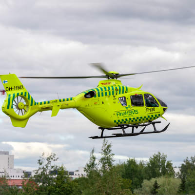 FinnHEMS neongula helikopter flyger.
