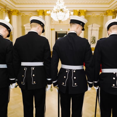Uniformsklädda kadetter med ryggarna vända mot kameran.