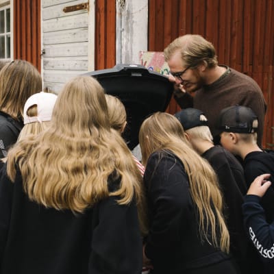 Luokanopettaja Janne Puolitaival esittelee koululaisille kompostin toimintaa.