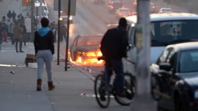 En bil brinner på en gata i Baltimore.