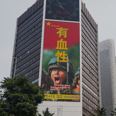 På en reklam på en husvägg syns en soldats skrikande ansikte och text på kinesiska.