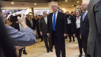 USA:s president står i en folksamling och blir fotograferad av pressen. 