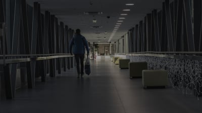 En man går i en mörk sjukhuskorridor.
