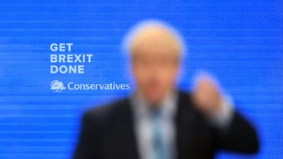 I bakgrunden testen: GET BREXIT DONE underskrivet av Conservatives. I förgrunden en helt suddig Boris Johnson som gestikulerar. 