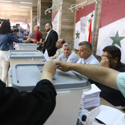 Syyrian presidentinvaalien äänestyspaikat avautuivat keskiviikkoaamuna. Kuvassa kerätään ääniä Syyrian pääkaupungissa Damaskoksessa.