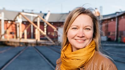 Marie Söderman står ute på gården vid lokstallet i Åbo.