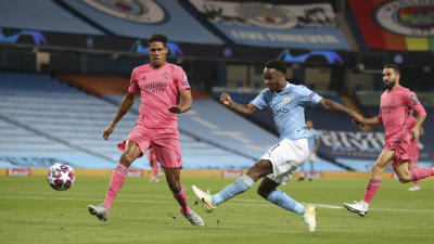 Raphael Varane försöker blockera ett skott från Raheem Sterling.
