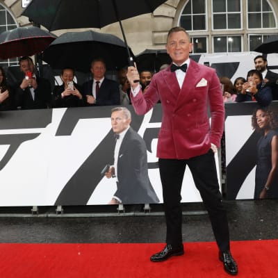 Daniel Craig sateenvarjon alla elokuvan No time to Die ensi-illassa.