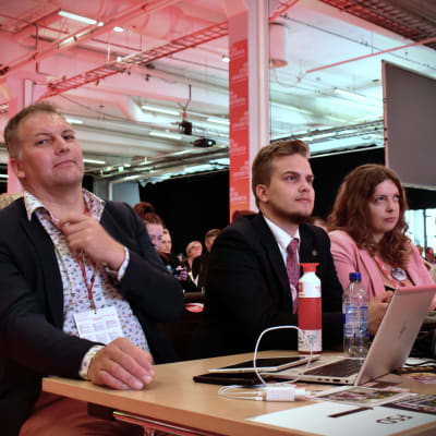 Viktor Kock, Jonatan Wikström och Rebecka Åkers sitter vid ett bord under socialdemokraternas partimöte i Jyväskylä.