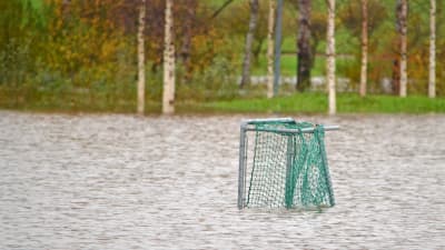 Ett fotbollsmål står på en översvämmad bollplan.