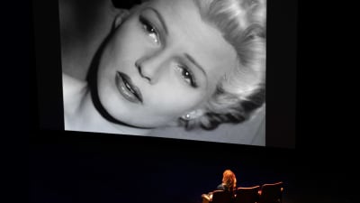 Elokuvaohjaaja Nina Menkes katsoo valkokankaalle heijastettua Rita Hayworthin kuvaa dokumentissa Brainwashed.