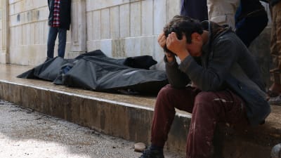 En syrisk man gråter intill tre liksäckar i rebellhållna Azaz, norra Syrien, efter ett bombdåd 3.5.2017