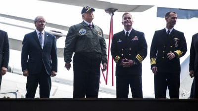 Donald Trump iklädd flygarjacka och skärmmössa på hangarfartyget Gerald R. Ford.