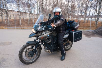 En iklädd motorcykelställ och hjälm sitter på en BMW motorcykel