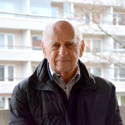Pjotr Zettinger fotograferaf framför en höghusfasad. 
